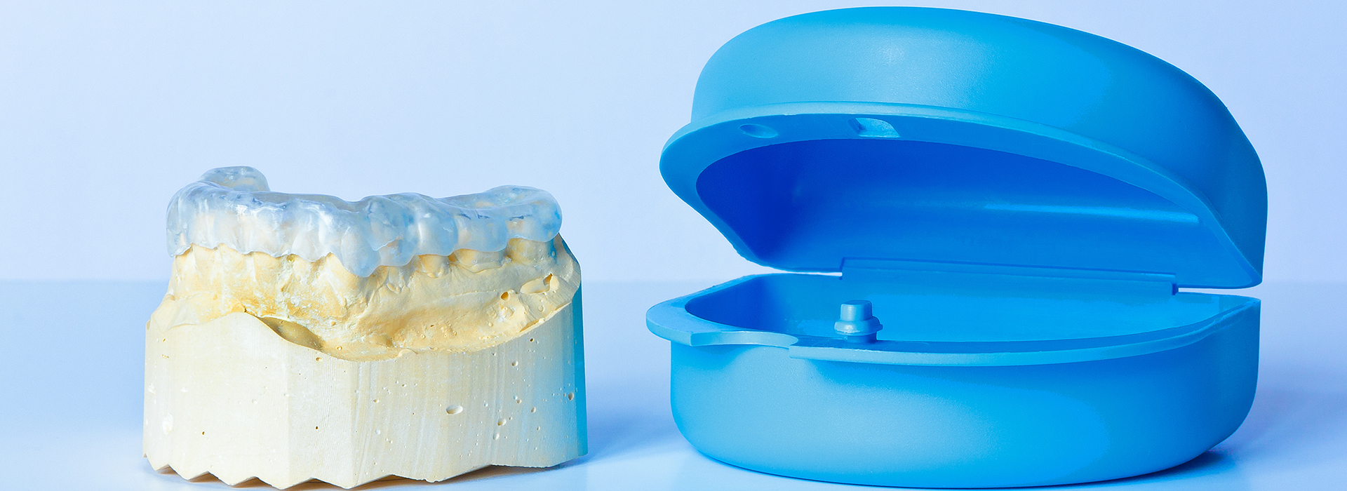 The image shows two dental implants, one with an attached abutment, placed on a white background.